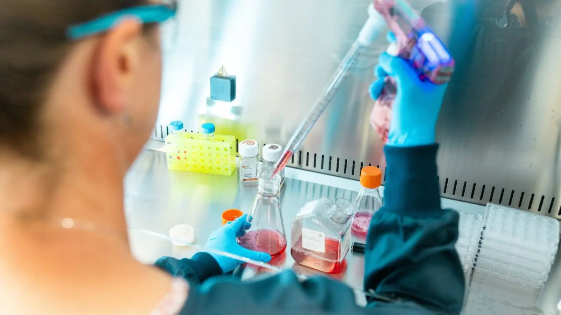 Person in hood working on virology assay