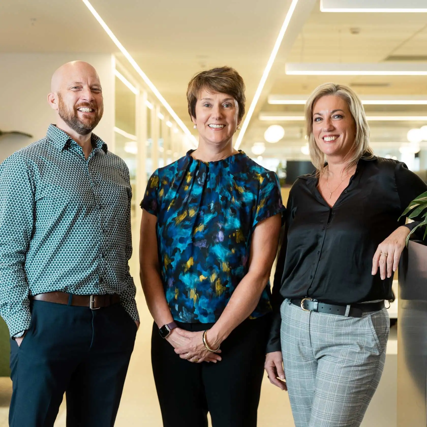 3 people standing in workplace